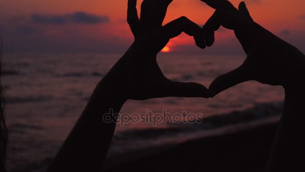  Γυναίκα χέρια δείχνουν καρδιά σχήμα πλαισιώνουν ήλιο στο ηλιοβασίλεμα - Πλάνα, βίντεο