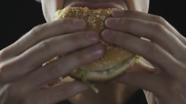Adam yakından ağır çekimde bir hamburger yiyor - Video, Çekim