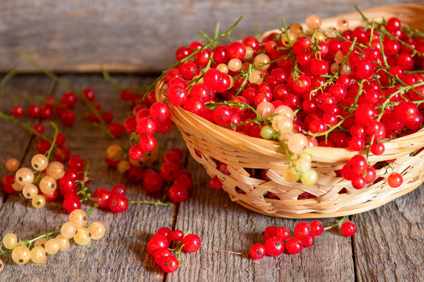 Red currant on brown wooden table - Foto, afbeelding
