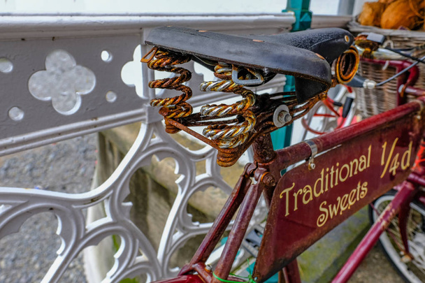 Παλιό ποδήλατο του καθίσματος ελατήρια wihth και αγγελία για γλυκά. - Φωτογραφία, εικόνα