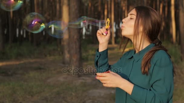 Lovely girl blowing soap bubbles - Felvétel, videó
