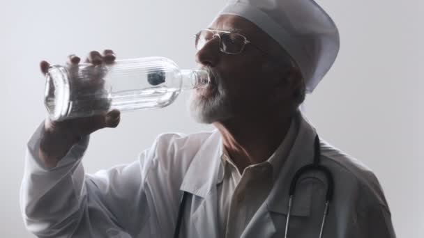 Porträt eines betrunkenen Arztes. ein medizinischer Mitarbeiter trinkt Wodka. - Filmmaterial, Video