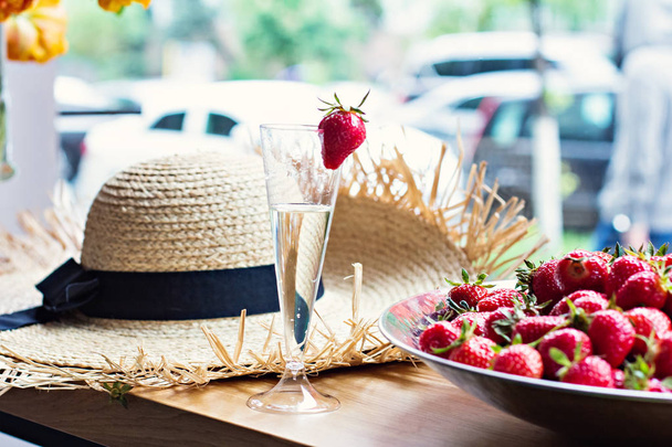 Schotel met aardbeien en champagne glazen op tafel. - Foto, afbeelding