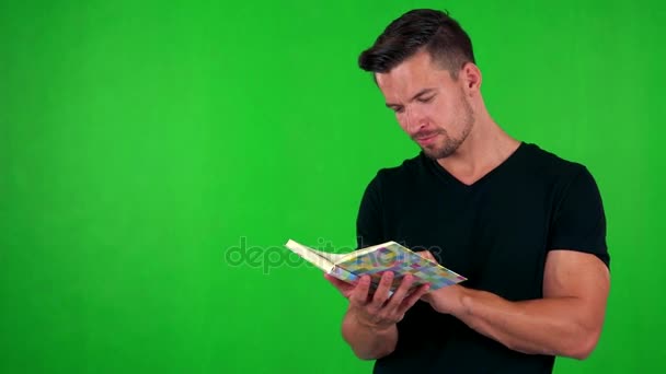 handsome man reads book - Záběry, video