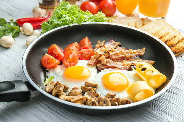 Frying pan with tasty eggs, bacon and mushrooms - Φωτογραφία, εικόνα