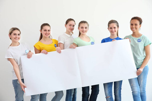 Young volunteers with poster on white background - Фото, зображення