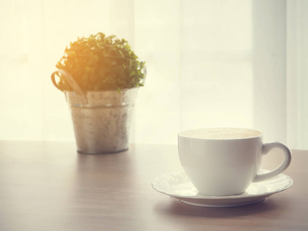 чашка кави латте кави, невеликий сад дерев на горщику і розмитий
  - Фото, зображення
