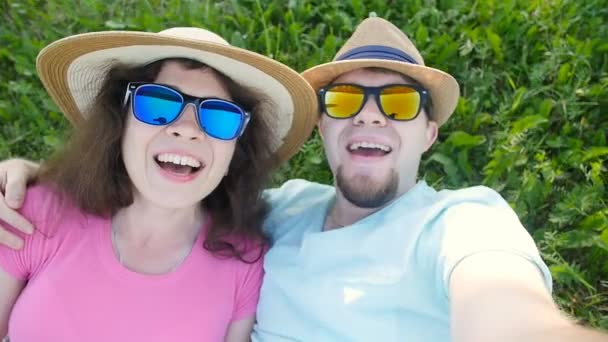 Nuori rakastava pari tekee selfie kun makaa nurmikolla
 - Materiaali, video
