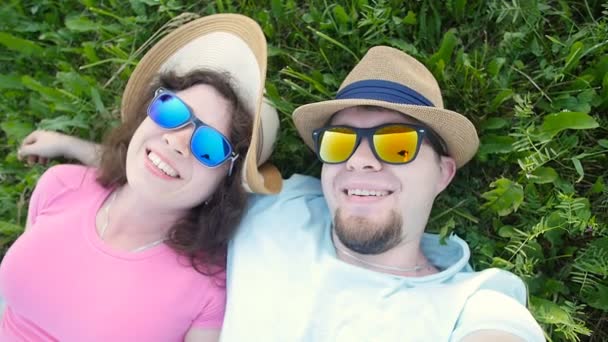Νεαρό ζευγάρι αγάπη λήψης selfie ξαπλωμένοι στο γρασίδι - Πλάνα, βίντεο