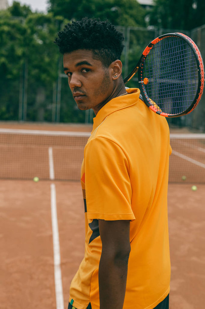 Szép komoly fiatalember póló ing gazdaság teniszütő - Fotó, kép