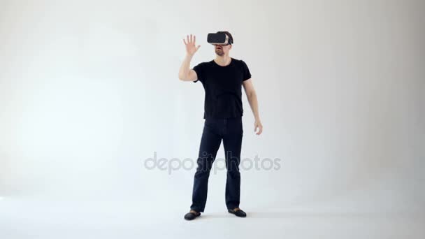 Un joven está mirando las gafas de realidad virtual
 - Imágenes, Vídeo