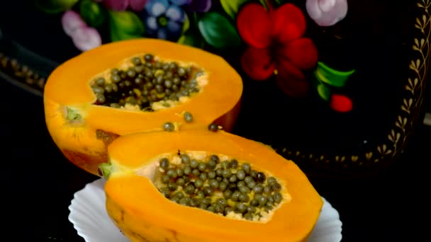 Tuore kypsä trooppinen papaija leikataan kahteen osaan modernissa keittiössä
 - Materiaali, video