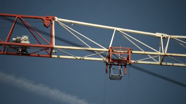 Кран на строительной площадке против голубого неба - Кадры, видео