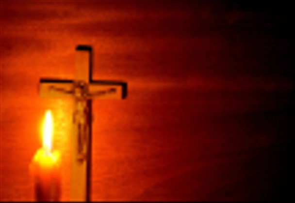 Fuego de vela y crucifijo en la oscuridad
 - Foto, imagen