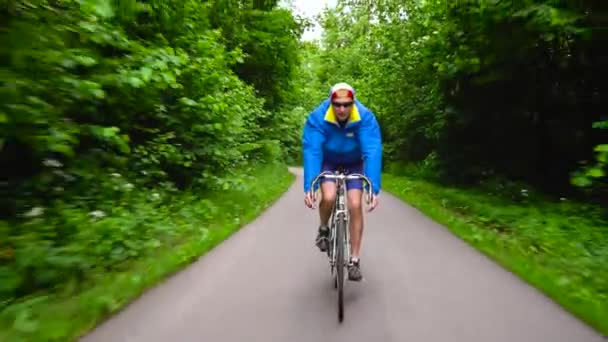 Homme d'âge moyen est en vélo de route le long d'une route forestière
 - Séquence, vidéo