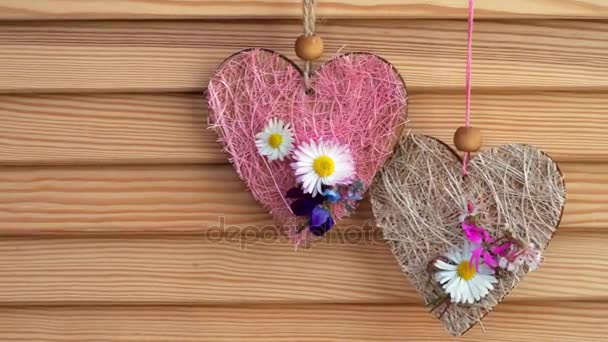 δύο καρδιές με τα μικρά λουλούδια κρέμονται από ένα ξύλινο υπόβαθρο με αντίγραφο χώρου - Πλάνα, βίντεο