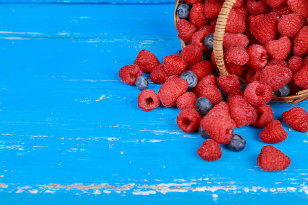 Fresh berry fruit pile basket with leaves placed on old wooden planks - Photo, Image