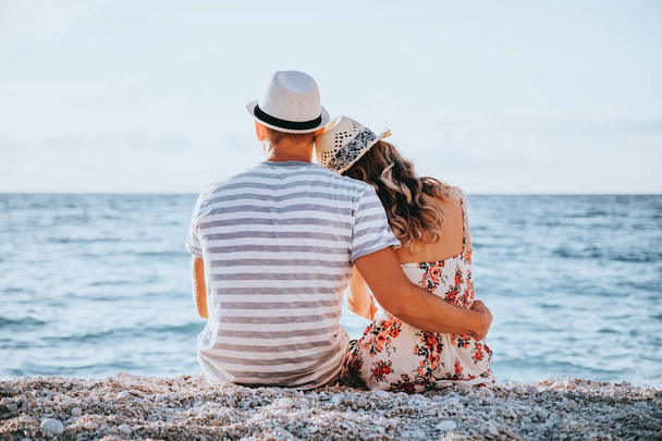 Young couple in love sitting on the beach - Valokuva, kuva