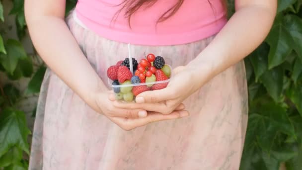 Zbliżenie na ręce kobieta trzyma jagody i owoce wymieszać - Materiał filmowy, wideo