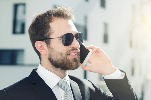 Handsome businessman talking on phone city outdoor - Фото, зображення