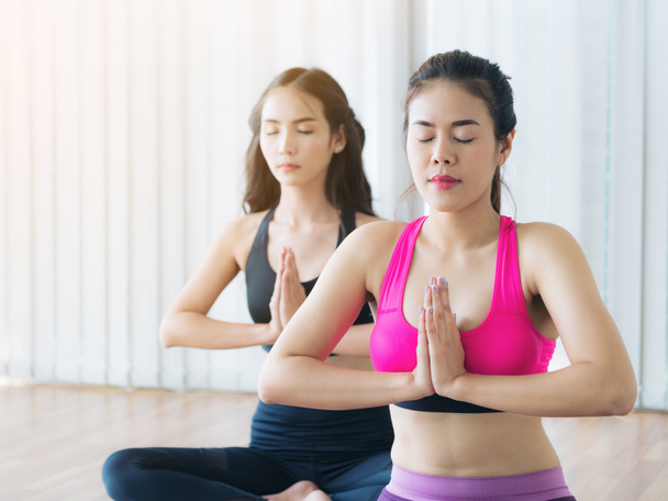 Mujeres practicando yoga posan en clase de gimnasia fitness
 - Foto, imagen