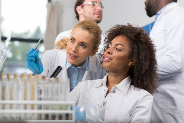 Two Female Scientist Examine Sample Working In Modern Laboratory, Group Of Researchers Making Experiment - Foto, afbeelding