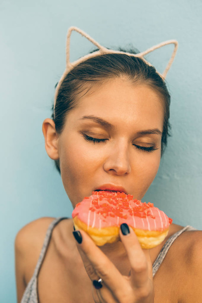 Sexy brunette lady eat sweet heart shaped donut. - Photo, Image