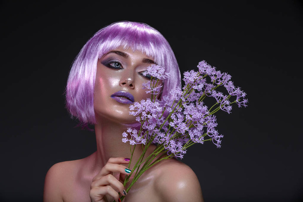Mooi meisje in paarse pruik met bloemen - Foto, afbeelding