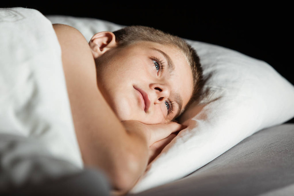 Child with open eyes with head on pillow - Valokuva, kuva