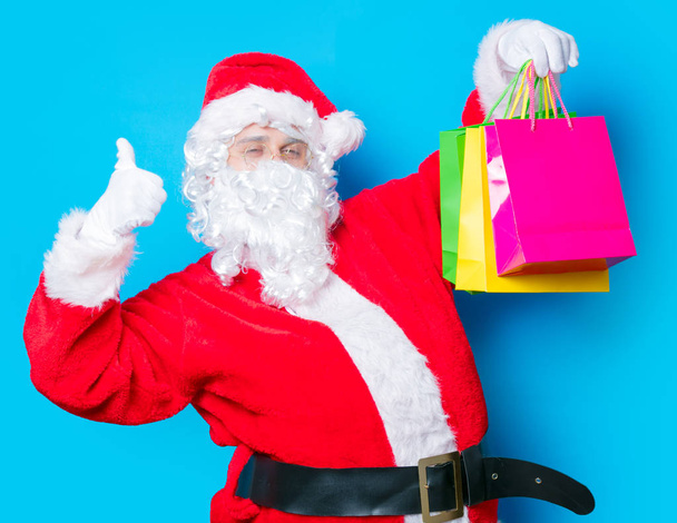 Санта-Клаус развлекается с сумками для покупок
 - Фото, изображение