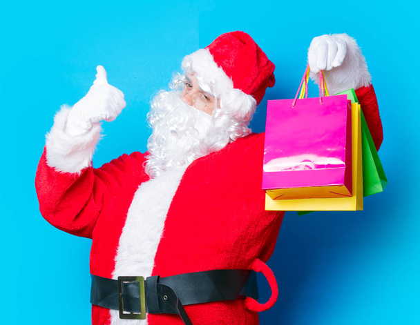 Weihnachtsmänner amüsieren sich mit Einkaufstüten - Foto, Bild