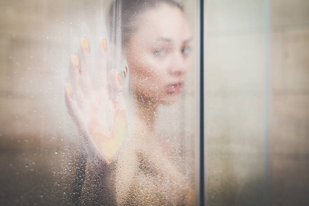 Young beautyful woman under shower in bathroom. - Foto, Bild