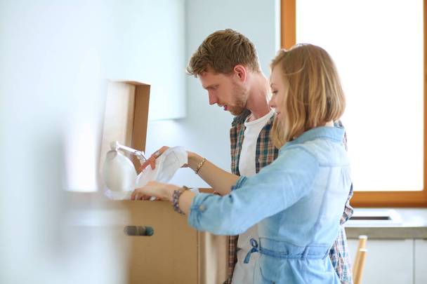 Young couple carrying big cardboard box at new home.Moving house - Foto, afbeelding
