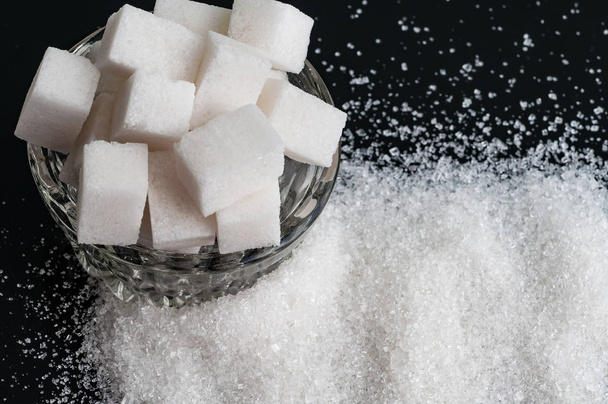 zucchero semolato bianco e zucchero raffinato su fondo nero
 - Foto, immagini