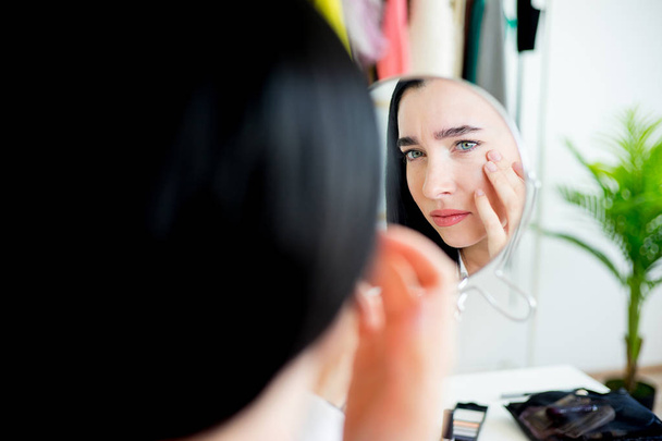 Woman applying make up - Foto, afbeelding