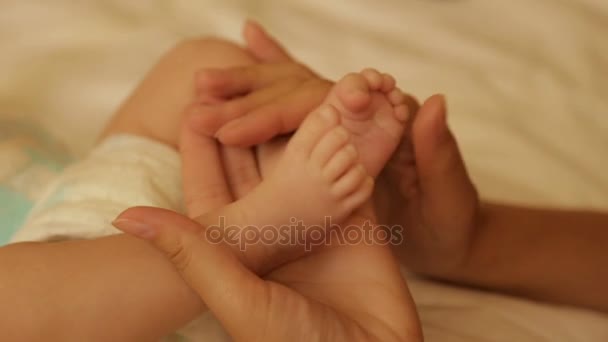 お母さんは、赤ちゃんの足を保持しています。 - 映像、動画