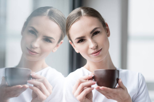 Happy attractive girl resting with hot drink indoors - Foto, immagini