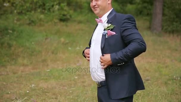 A stylish bride with a boutonniere fastens a jacket - Footage, Video
