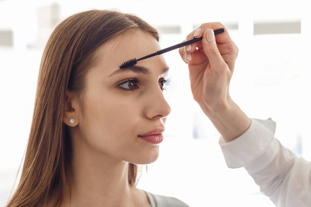 Portrait of a beautiful model during an eyebrow correction procedure - Fotoğraf, Görsel