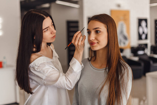 Beautiful young girl got correction of eyebrows in a beauty salon. - Fotoğraf, Görsel