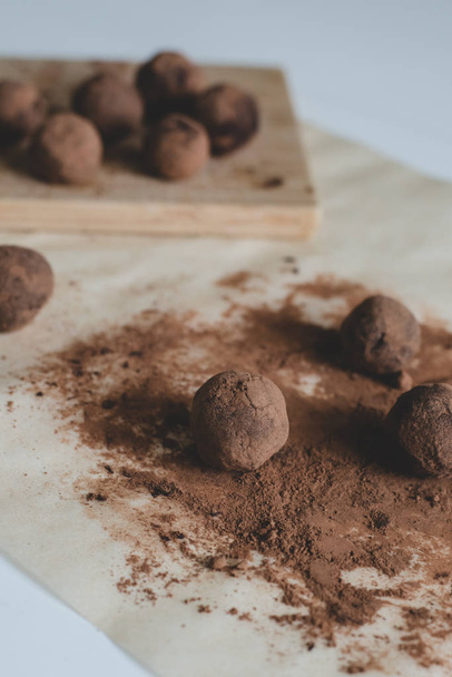 A process of making healthy dessert: Chocolate truffles on a parchment paper with cocoa powder. - Valokuva, kuva