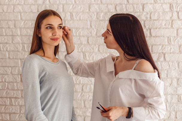 Model and makeup artist make a new form natural eyebrows. - Fotoğraf, Görsel