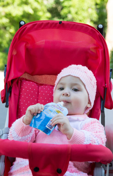 Το μωρό τρώει ένα πουρέ από ένα σούπερ μάρκετ - Φωτογραφία, εικόνα