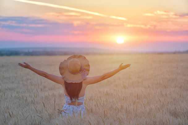 Frau fühlt sich frei, glücklich und geliebt in einer wunderschönen natürlichen Umgebung bei Sonnenuntergang - Foto, Bild