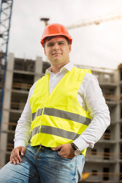 Smiling construction engineer in hardhat looking at camera - Foto, imagen