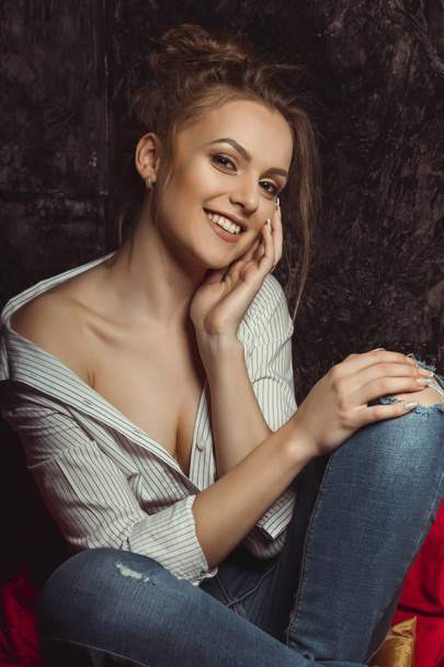 Smiling  brunette lady with natural makeup in shirt and torn jea - Zdjęcie, obraz
