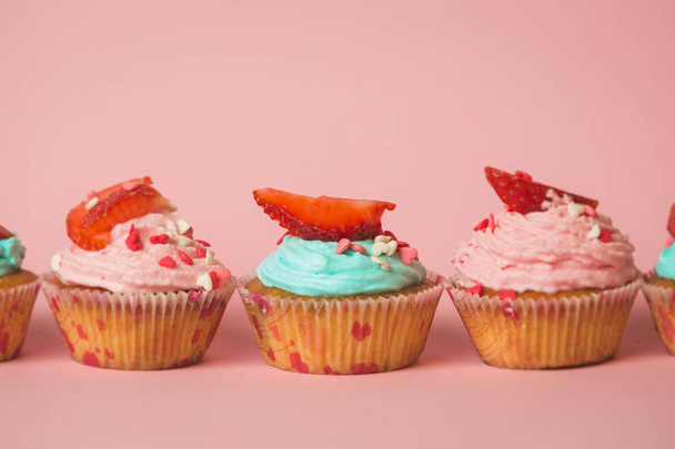 Foto de cerca de cupcakes de colores con aspersiones y stra fresca
 - Foto, Imagen