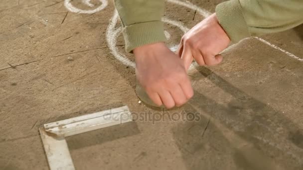 Close Up van een jonge smid die een krijt trekt handen schets op de tabel met behulp van het slijpen wiel - Video