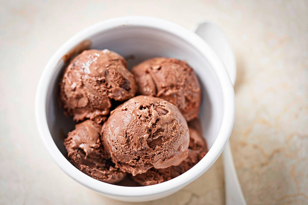 Шоколадное мороженое с кусочками пирожных в белой миске
  - Фото, изображение