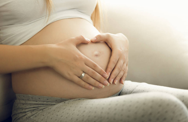 Foto di primo piano della madre premurosa incinta che tocca la pancia
 - Foto, immagini